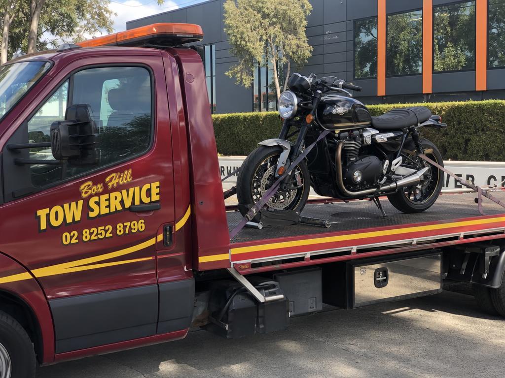 Motorbike strapped to a Box Hill Tow Service tow truck deck